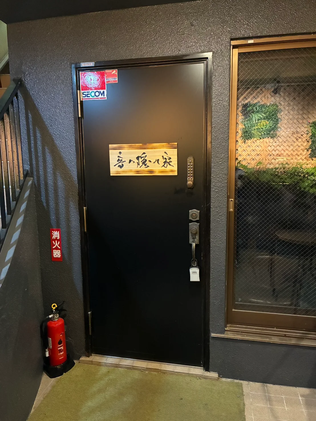 音の隠れ家の木製看板が付いた入口ドア